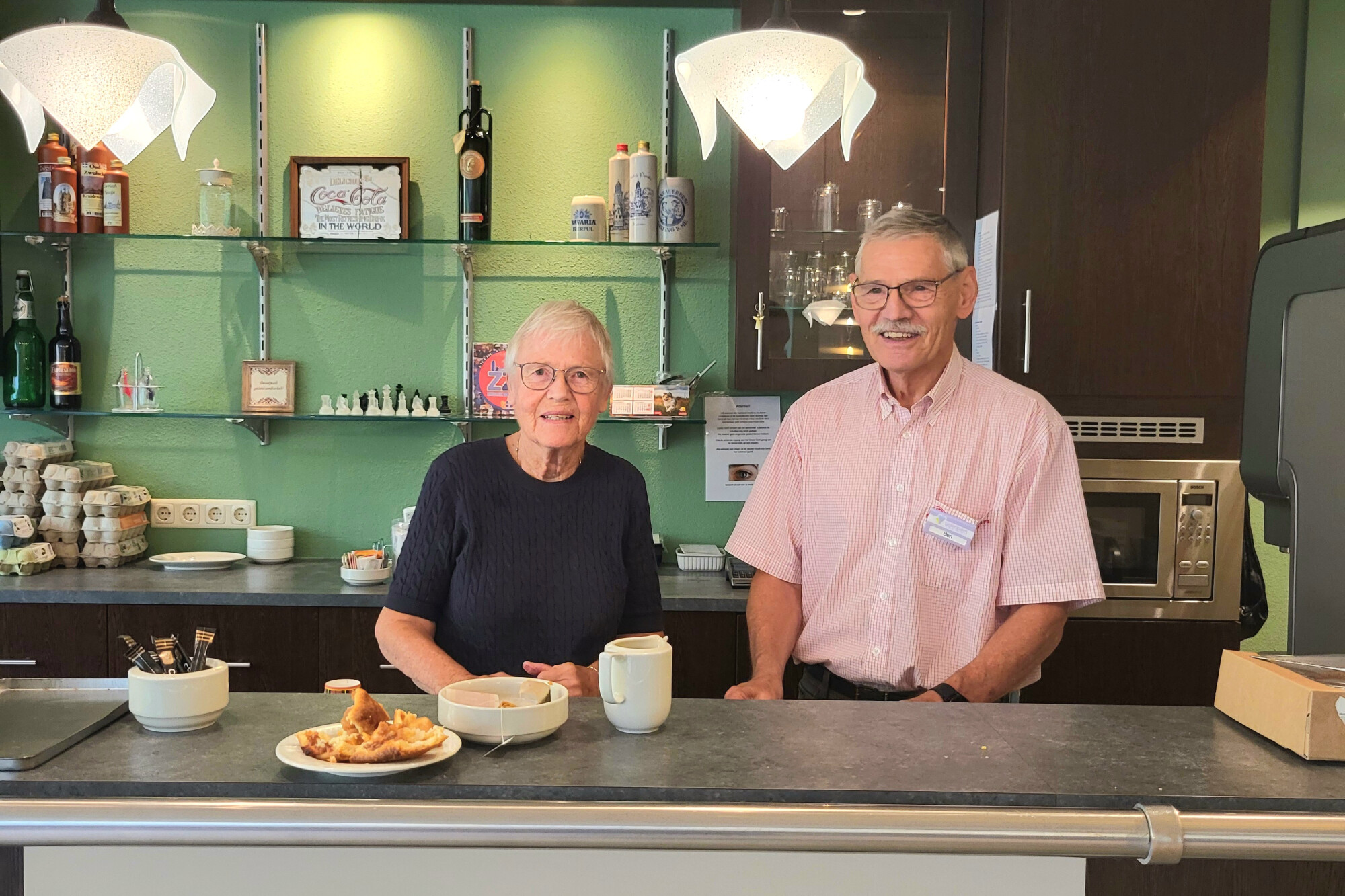 Twee vrijwilligers achter de bar bij het Grand Café in Fermate.